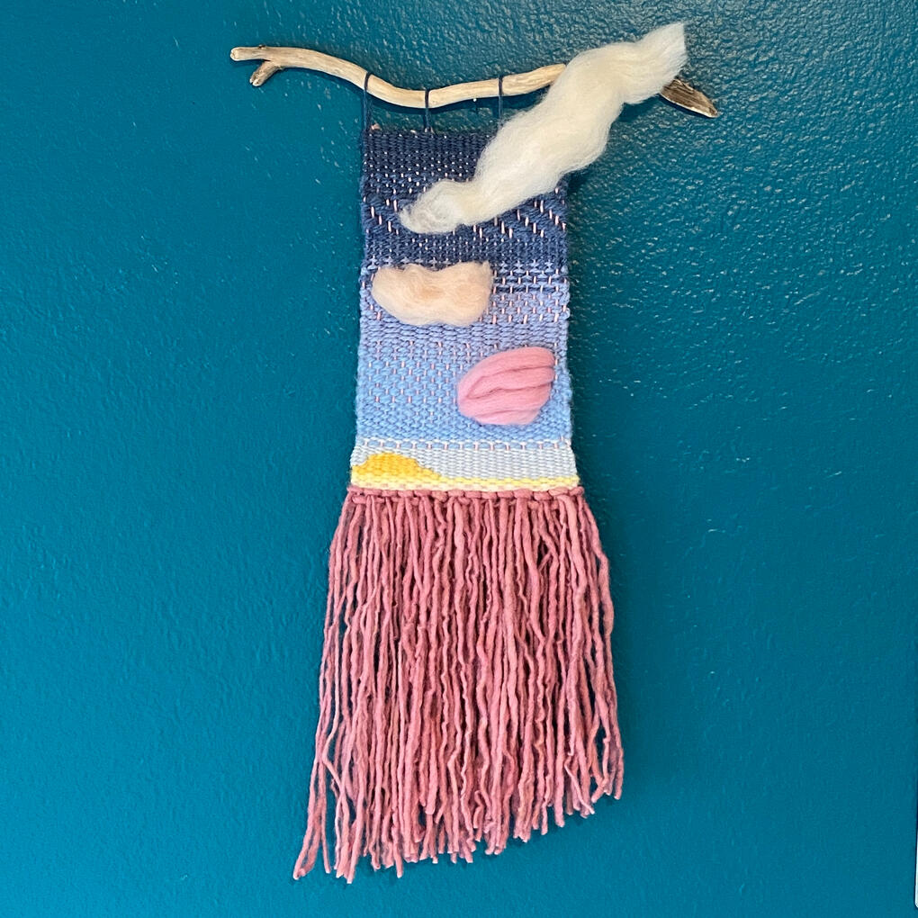 A weaving evoking a cloudy sunset using hand-died pink yarn.